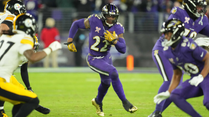 Baltimore Ravens football player Derrick Henry running while carrying a football.