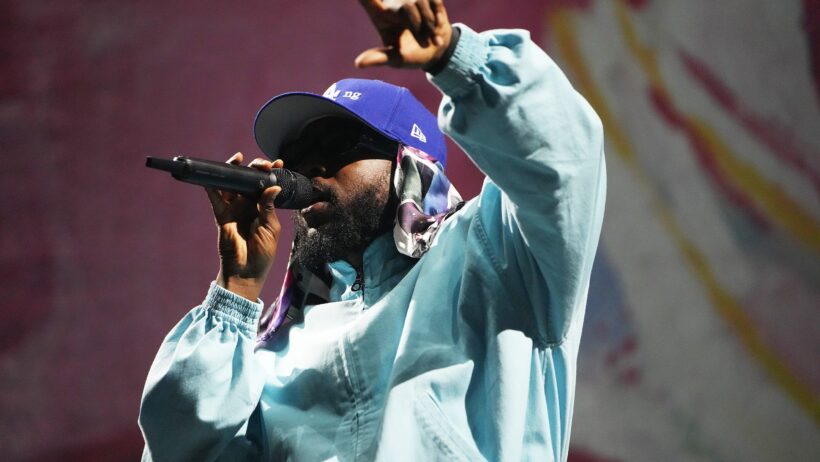 Rapper Kendrick Lamar singing into a microphone.